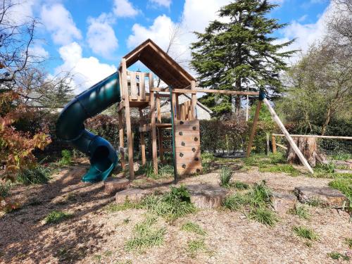 a playground with a slide in a yard at Little Underhill in Oswestry