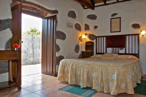 a bedroom with a bed in a room with a window at Casa Rural El Palmeral del Valle in Santa Lucía