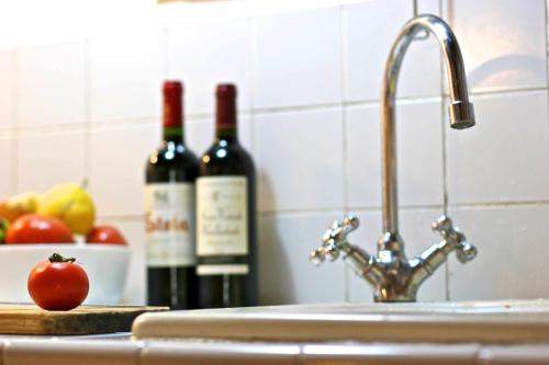 two bottles of wine on a counter next to a sink at Casa Rural El Palmeral del Valle in Santa Lucía