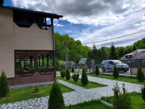 Rîuşor的住宿－Pensiunea Perla Râușor，停在房子旁边的车道上的汽车