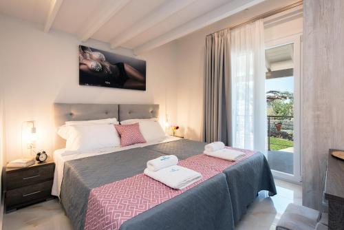 a bedroom with a bed with two towels on it at AD HOMES in Agios Gordios