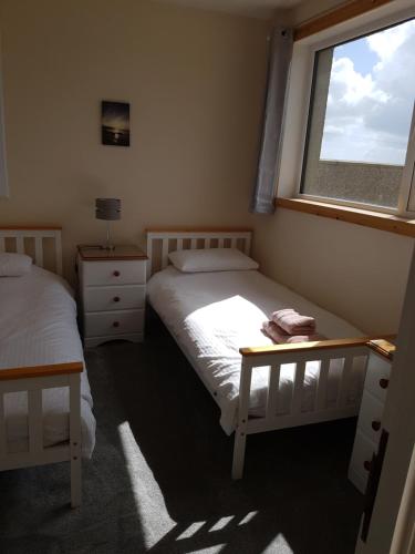 a bedroom with two beds and a window at Lindisfarne Self Catering in Navershaw