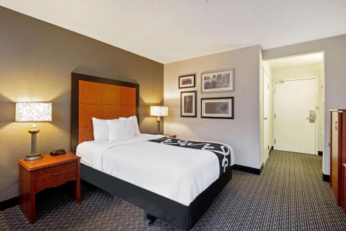 a hotel room with a large bed and a table at La Quinta by Wyndham Harrisburg Airport Hershey in Harrisburg
