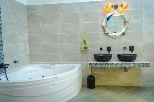 a bathroom with a large tub and a mirror at Golden Duranta Villas in Ukunda