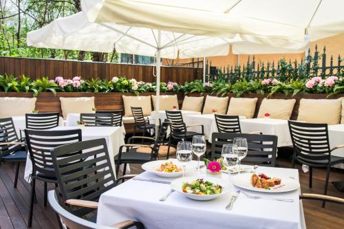 a restaurant with white tables and chairs with plates of food at Crystal Palace Boutique Hotel in Sofia