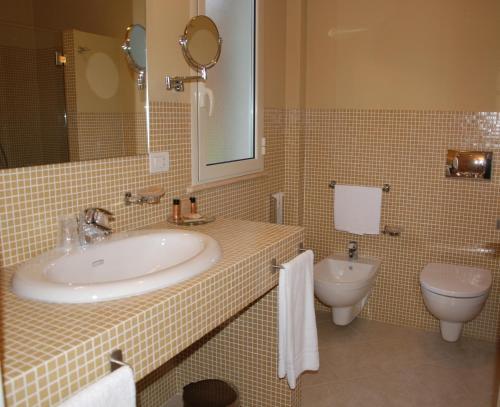 ein Bad mit einem Waschbecken und einem WC in der Unterkunft Alcantara Resort di Charme Adults Only in Gaggi