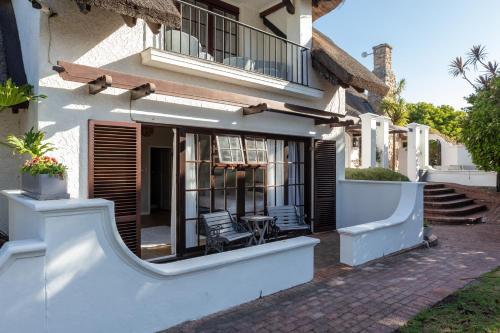 a house with a porch with two chairs in it at Whale Rock Luxury Lodge in Hermanus