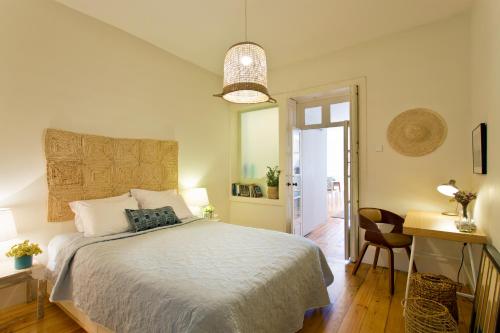 ポルトにあるOwn Places Cedofeita Apartmentsのベッドルーム1室(ベッド1台、テーブル、椅子付)