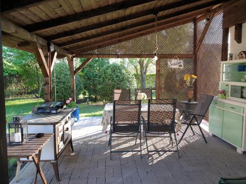 a patio with a table and chairs under a pergola at Lovely Cottage Home in Velence