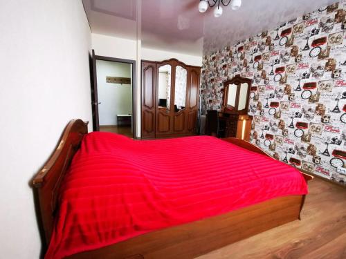 エッセントゥキにあるКвартира ул. Кисловодскаяのベッドルーム1室(赤いベッド1台、絵画の壁付)