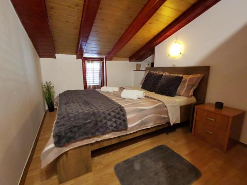 a bedroom with a large bed and a wooden ceiling at Apartment Orkić in Rovinj