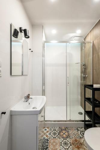 a white bathroom with a shower and a sink at ShortStayPoland Pańska in Warsaw