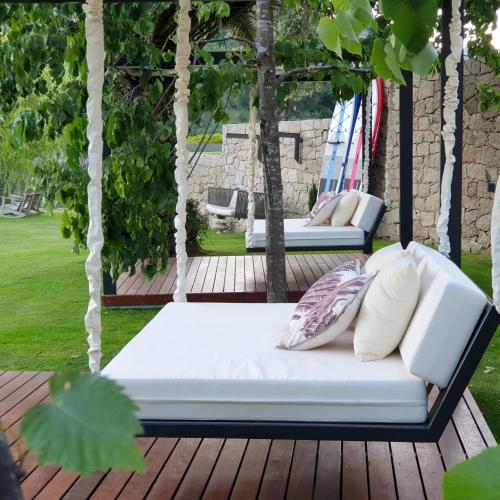 a white couch on a porch with pillows at Douro Suites in Riba Douro