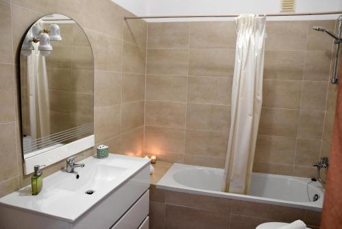 een badkamer met een wit bad en een wastafel bij Altura Beach in Altura