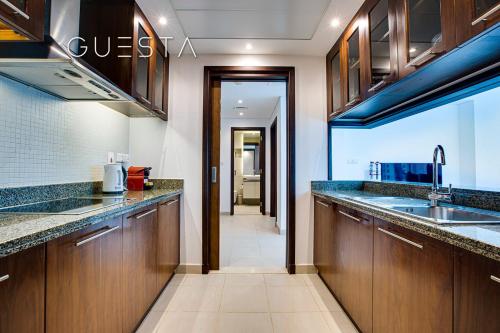 a kitchen with wooden cabinets and a sink at Marina Promenade - Paloma Tower, Dubai Marina in Dubai