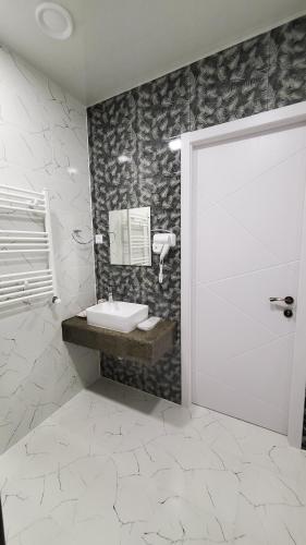 a bathroom with a sink and a white door at Kvareli Oaks in Kvareli