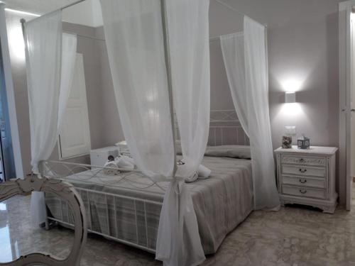 a bedroom with a bed with curtains and a dresser at Palazzo Mosca in Sannicola