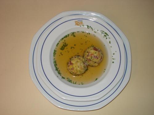 a plate with two meatballs in a yellow broth at Sporthotel Rasen in Rasùn di Sotto