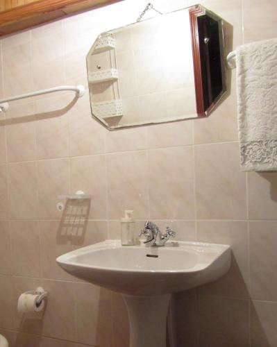 a bathroom with a sink and a mirror at Casa Encantada - Alvoco da Serra in Alvoco da Serra