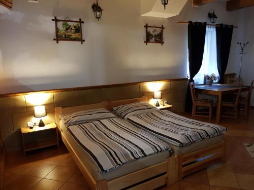 1 dormitorio con 1 cama, 1 mesa y 2 lámparas en Ubytovanie pod Hradom, en Sklené Teplice
