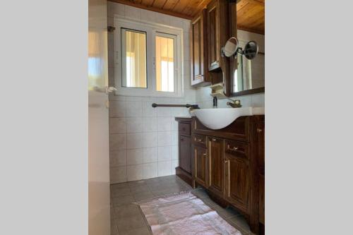 W łazience znajduje się umywalka i lustro. w obiekcie 360º suite with endless views to the Ionian Sea w mieście Mitikas