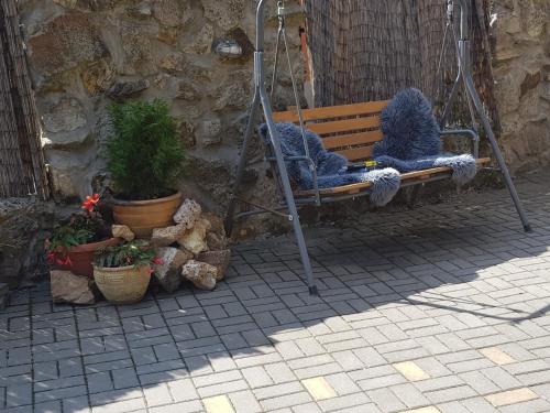 a swing with two blue chairs and potted plants at Ubytovanie pod Hradom in Sklené Teplice