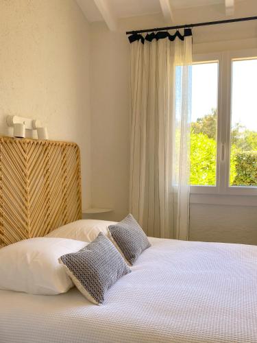 a bedroom with a white bed with a window at Les Mas Méditerranée in La Croix-Valmer