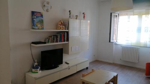 uma sala de estar com uma televisão num armário branco em Casa Posa em Bari