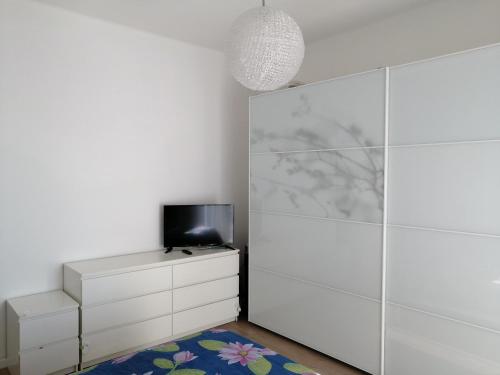 um quarto branco com uma televisão e uma cómoda em Casa Posa em Bari