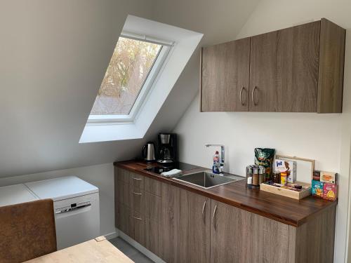 uma pequena cozinha com um lavatório e uma janela em Ferienwohnung Möwe 14 em Schleswig