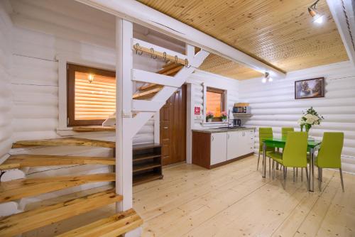 a kitchen and dining room with a spiral staircase in a tiny house at Domy z Bala - Domki ogrzewane - JACUZZI, SAUNA, lody, popcorn, ryba wedzona i ognisko w cenie! in Dziwnówek