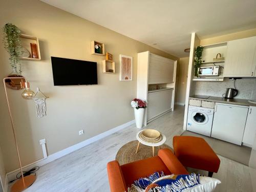 a living room with a couch and a tv on a wall at My Little Provence Bormes Les Mimosas in Bormes-les-Mimosas