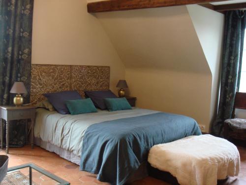 a bedroom with a large bed with blue pillows at Moulin de Giboudet Chambres d'hôtes in Bazainville