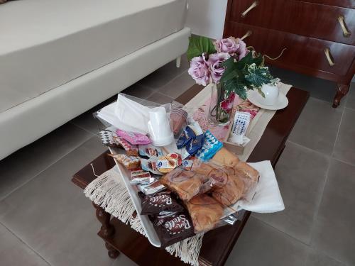a table with food and a vase of flowers on it at B&B Petra Hercules in Torre Annunziata