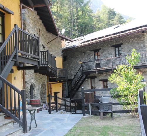 a stone building with stairs and benches in front of it at Residence Covalou in Antey-Saint-André