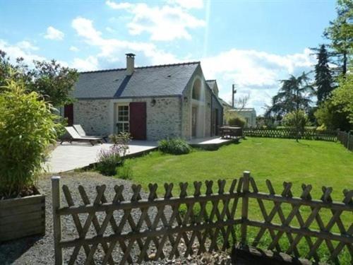 a house with a fence in front of a yard at Au Bas Chalonge Gite Le Four à Pain in Ligné