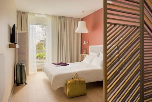 Un pat sau paturi într-o cameră la OKKO Hotels Lille Centre