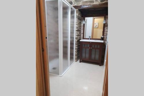 a bathroom with a glass shower and a sink at Apartamento con vistas al río A Solaina in Samos