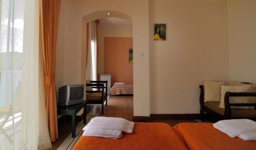 a room with two beds and a tv and a couch at Golden View in Poros
