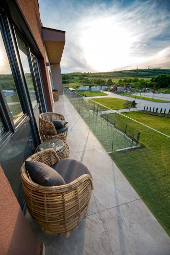 a balcony with chairs and a view of the water at Allure Healthy Hotel & Spa in Eger
