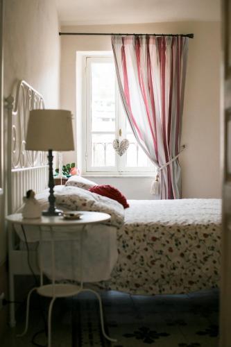 a bedroom with a bed and a table and a window at BB Le Gemme in Dolceacqua