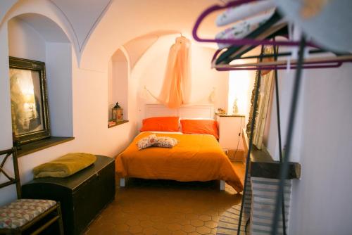 a bedroom with a bed with an orange bedspread at BB Le Gemme in Dolceacqua
