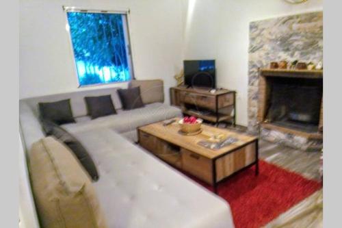 a living room with a couch and a fireplace at Lagonisi MAGIC HOME RELAXATION in Kalívia Thorikoú