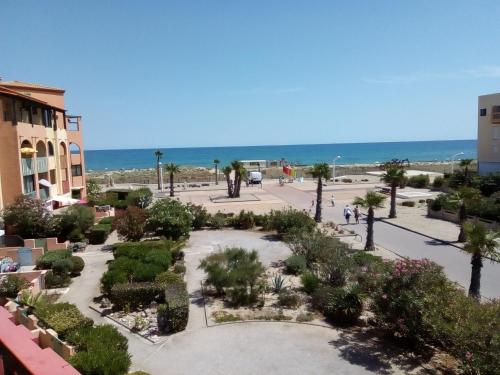 - une vue sur un parc avec l'océan en arrière-plan dans l'établissement Petit appartement Le Victoria's Beach Barcarès - Parking privé - Direct plage - 5 minutes à pied du Lydia - 3 Personnes - Pas de linge de maison - Pas de Wifi - Pas de climatisation -, au Barcarès