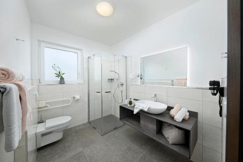 a white bathroom with a sink and a shower at Appartement-Hotel Beatenhof in Tirolo