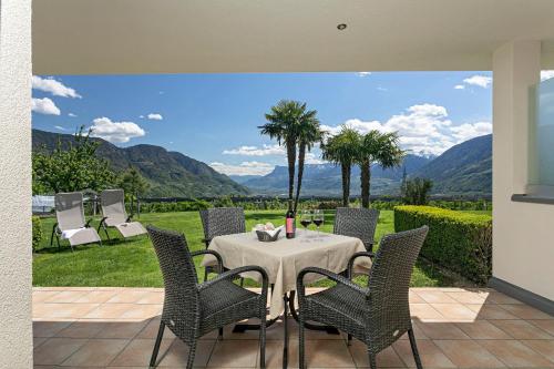 a table and chairs with a view of mountains at Appartement-Hotel Beatenhof in Tirolo