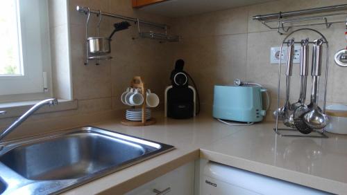 a kitchen with a sink and a counter top at Apartamento Girassol Cabanas Gardens by Your Home Algarve in Cabanas de Tavira