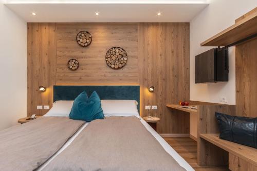 een slaapkamer met een groot bed en houten wanden bij Hotel Pejo in Peio Fonti