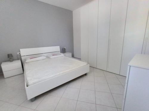 Un pequeño dormitorio blanco con una cama blanca. en Bastione, en Gela