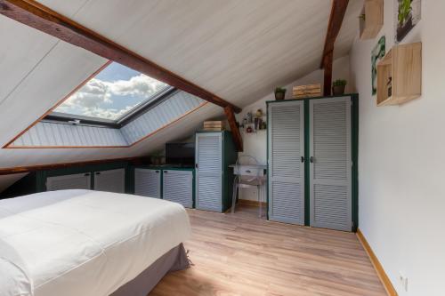 a attic bedroom with a bed and a window at Appart près de Disneyland «les yeux vers le ciel » in Meaux